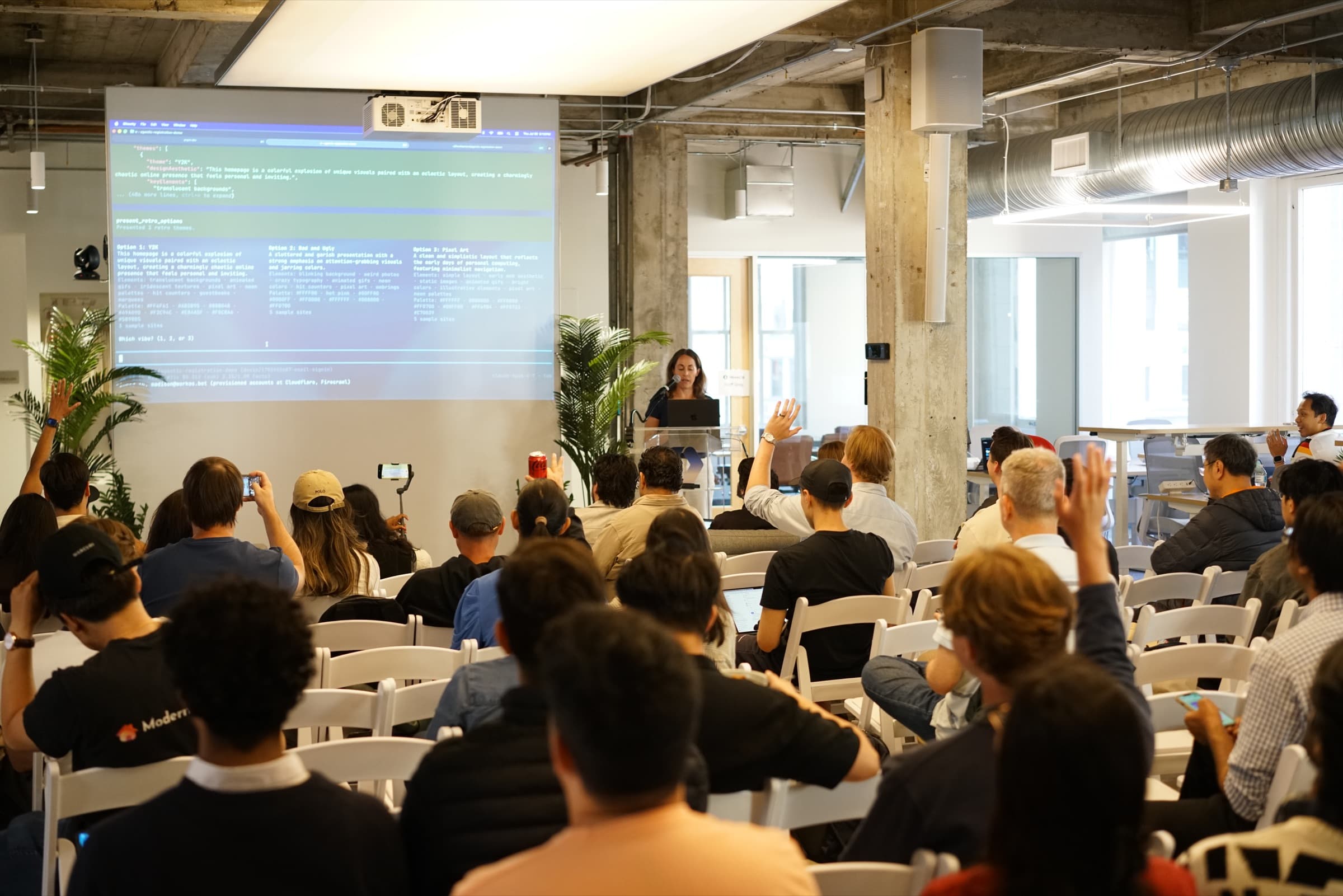 Audience members raise their hands during a presentation at the Pieces × WorkOS event in San Francisco.